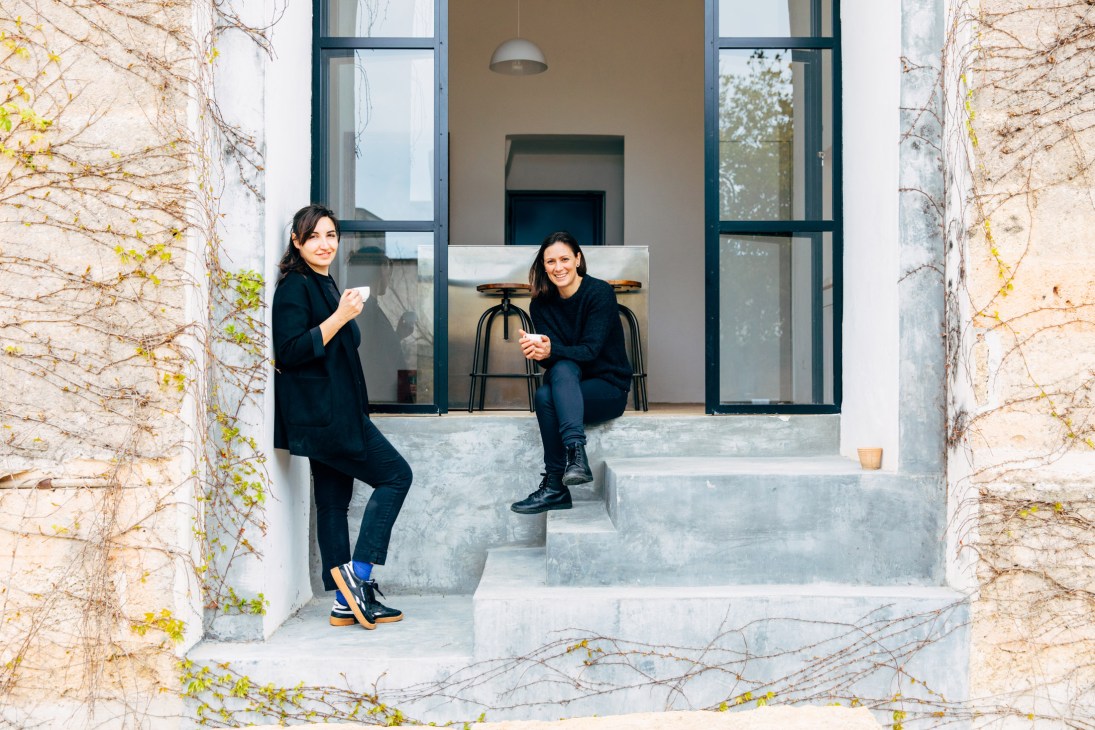 Federica de Giorgi and Elisa Rossi sit on steps at Palazzo Daniele hotel in Puglia.