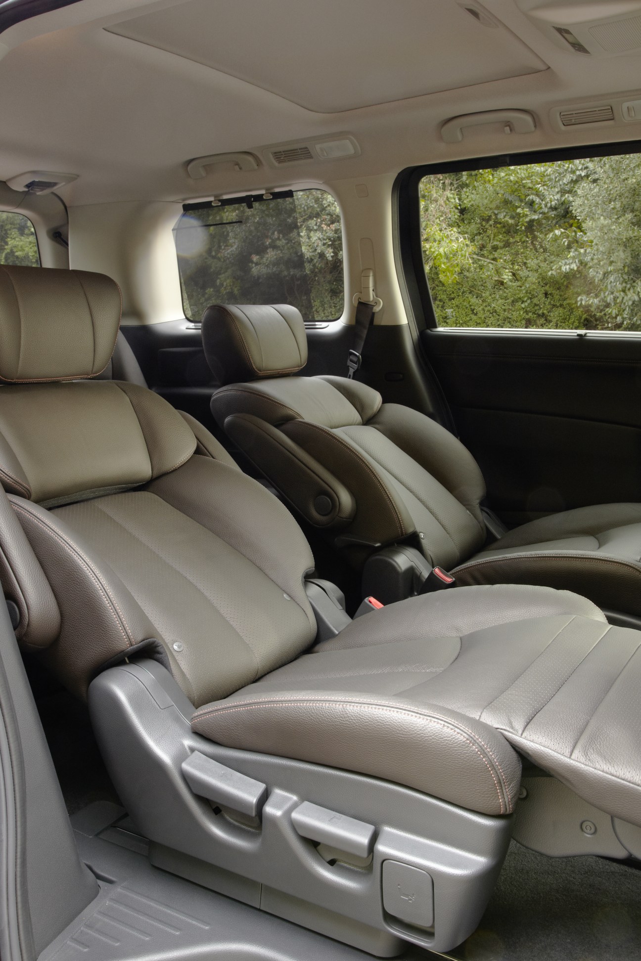 Interior of a Nissan Elgrand Highway Star minivan with cream leather reclining seats and presentation facilities.