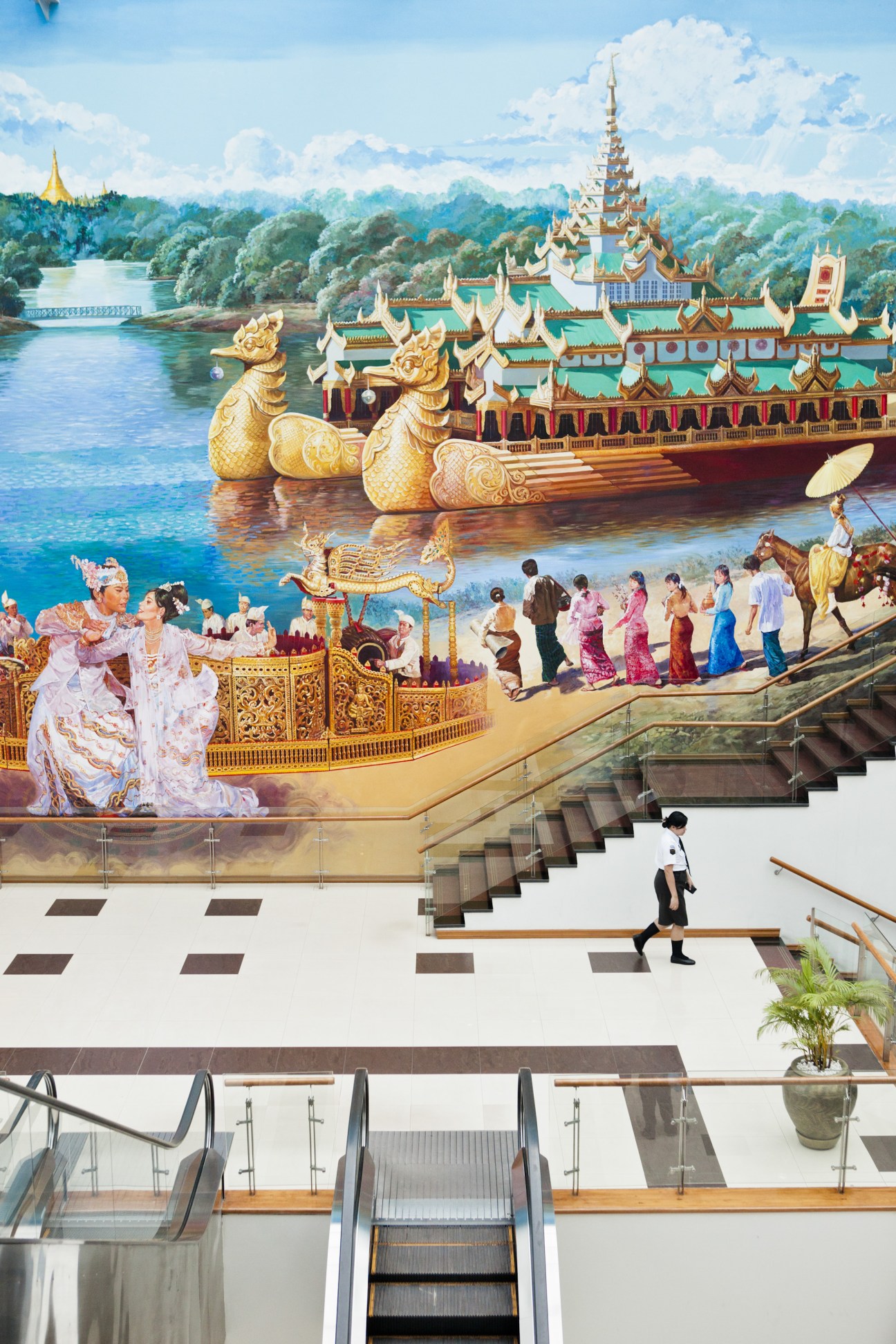 Mural depicting traditional Burmese palace and river scene at Yangon International Airport.