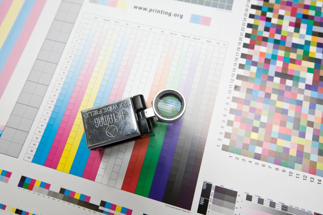 Color reference chart and magnifying glass tool used for testing print quality during production.
