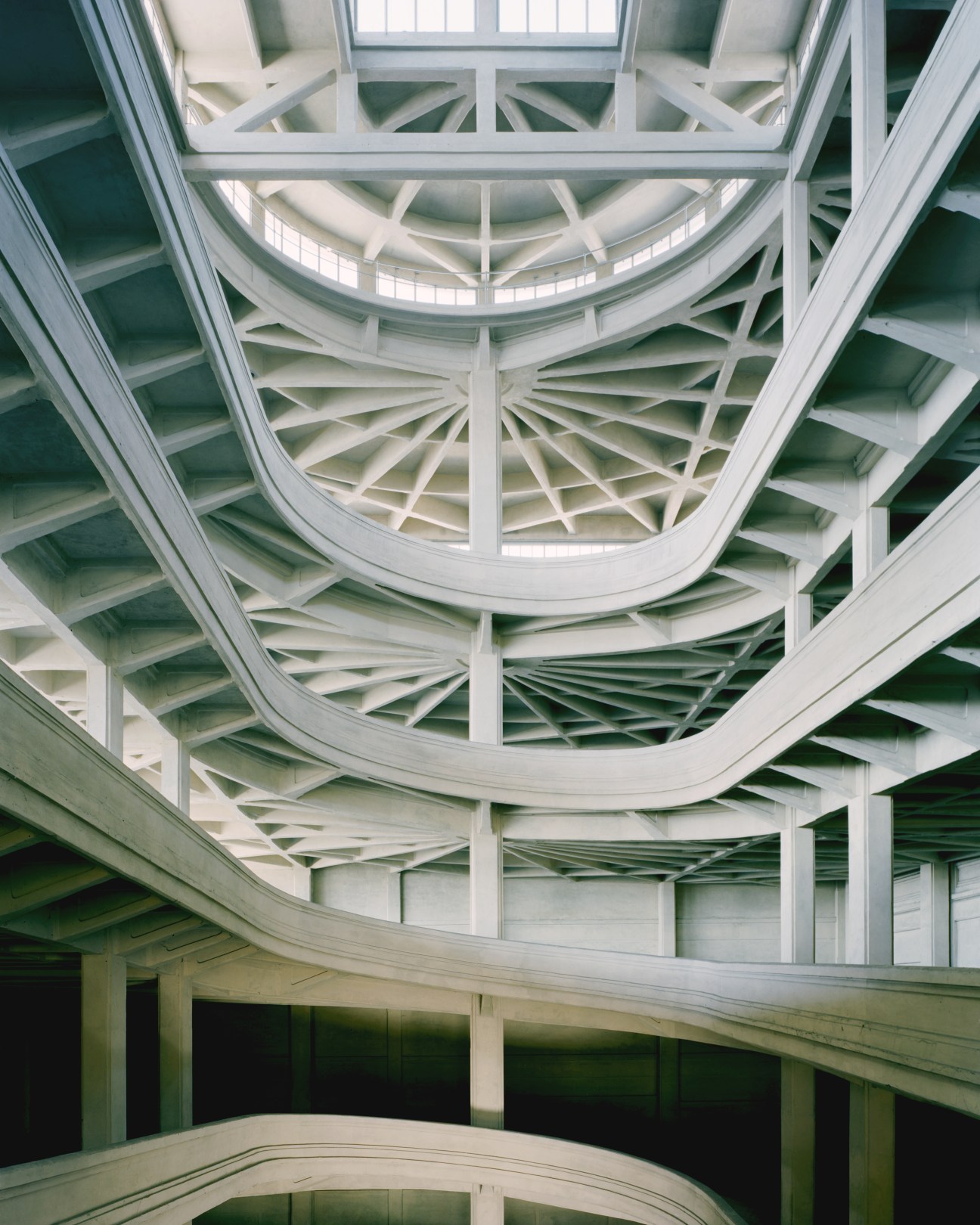 Geometric ceiling of the Lingotto factory with concentric circular architectural framework and radiating beams.