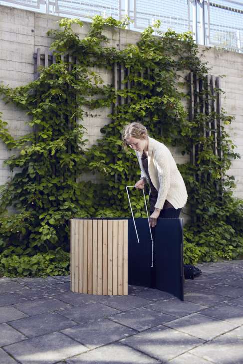 Student Lovisa Nersing demonstrates a raised wooden flowerbed design against an ivy-covered wall.