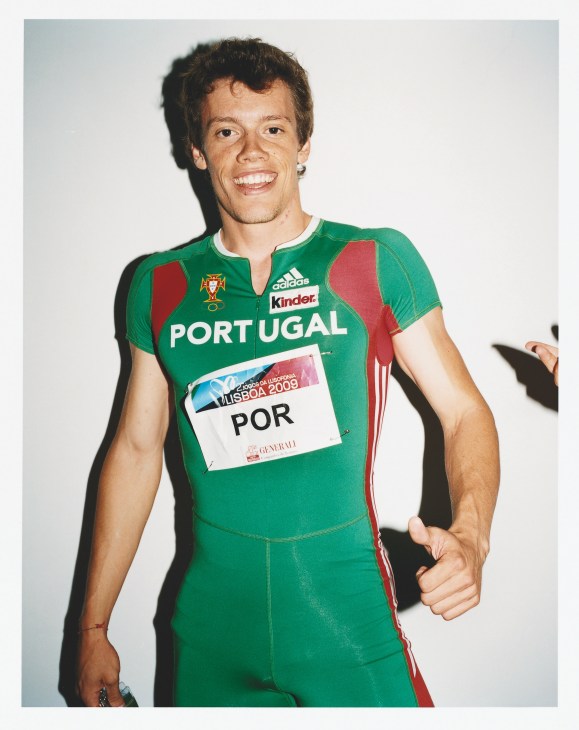Portuguese sprinter in green Adidas tracksuit with Portugal crest and sponsor logos at Jogos da Lusofonia.