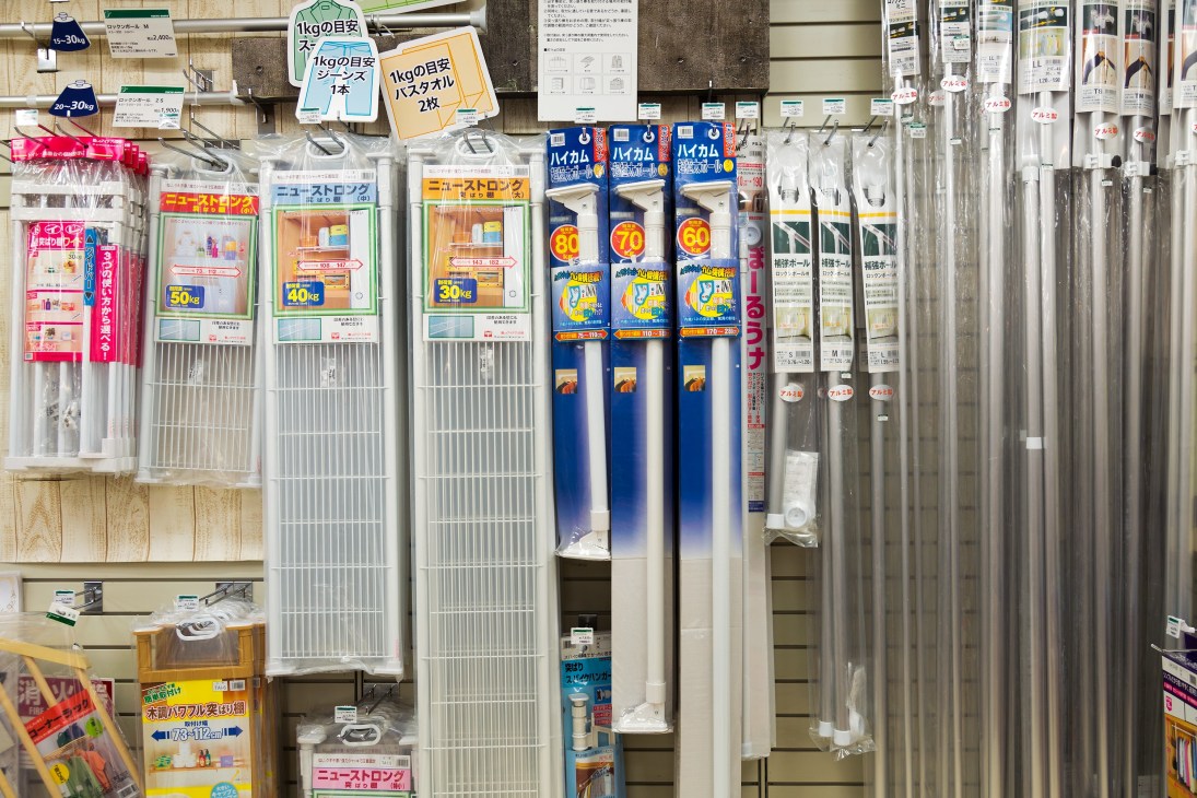 Display of adjustable poles and racks with Japanese product packaging at Tokyu Hands store.