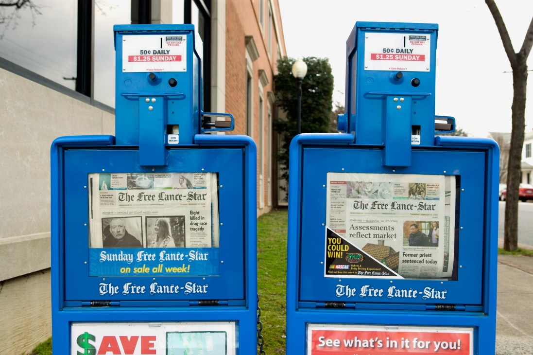 Two blue newspaper vending machines displaying The Free Lance-Star on a street in Virginia.