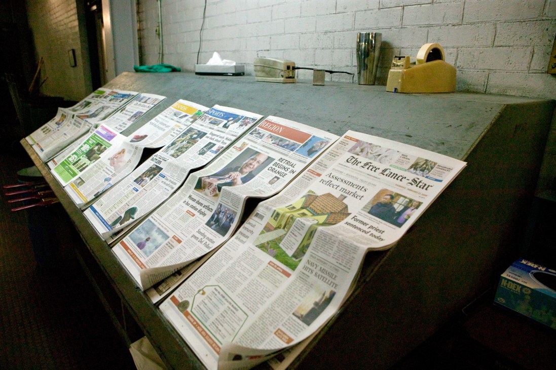 Various sections of the Free Lance-Star newspaper laid out on a table.