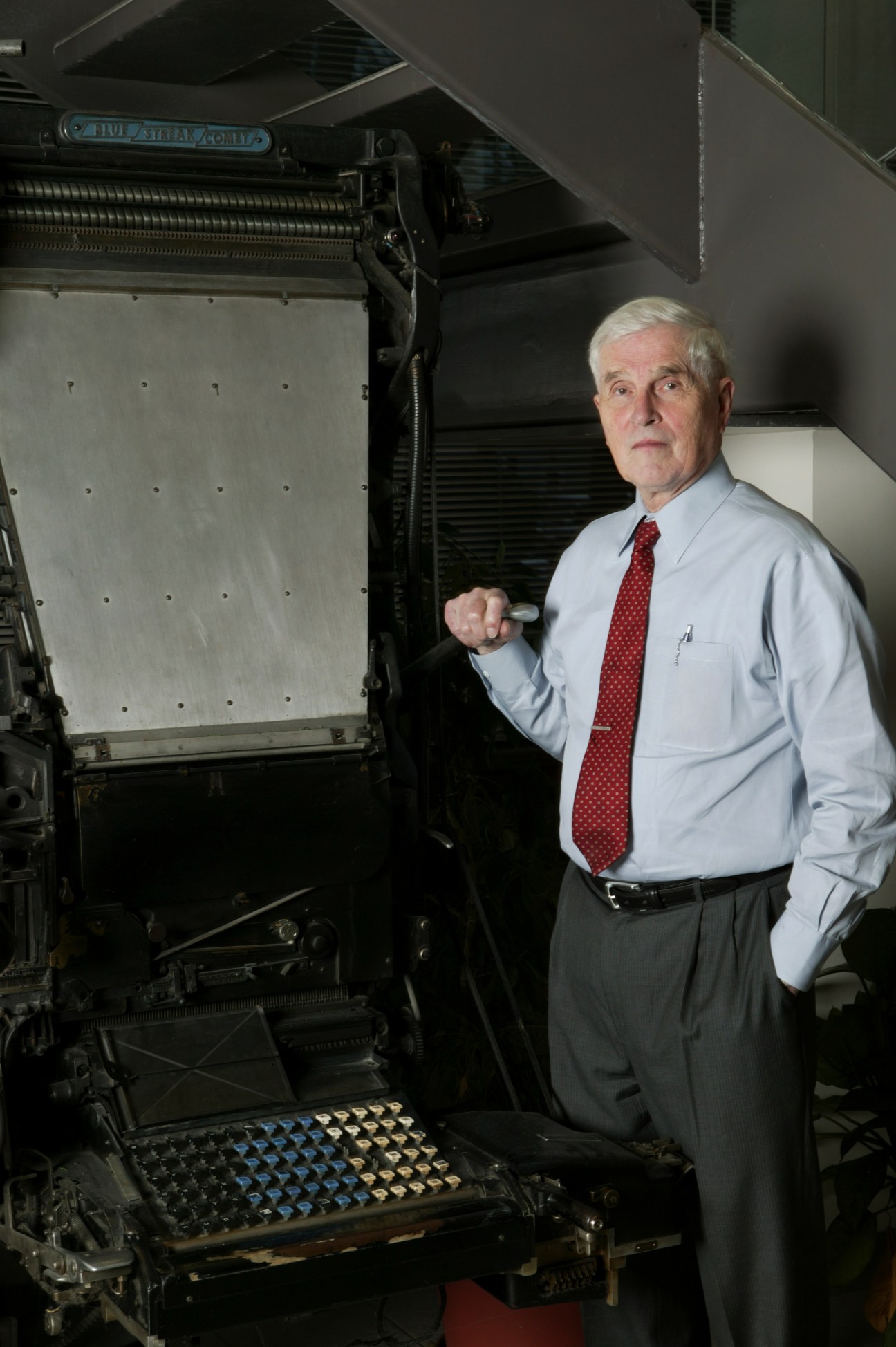 Josiah Rowe III stands beside a retired Linotype machine at the Free Lance-Star newspaper facility.