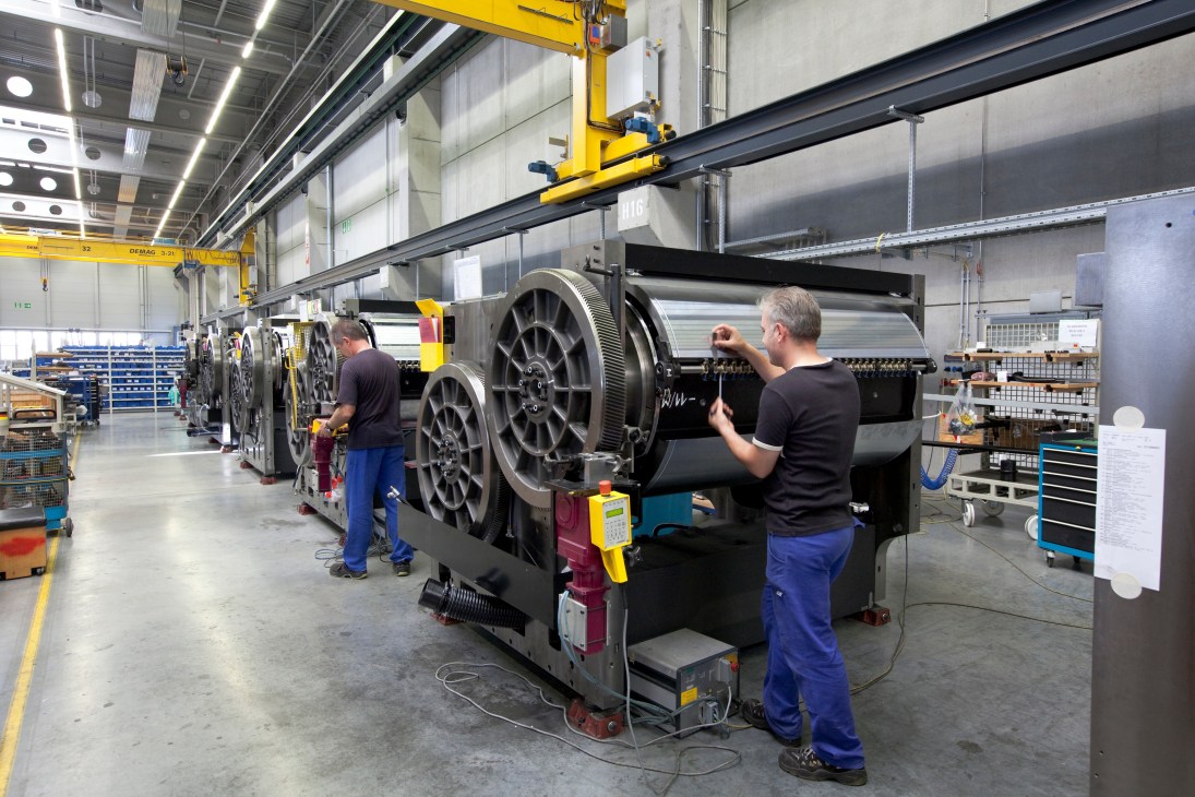 Technicians assembling a large printing machine on the factory floor at Heidelberg.