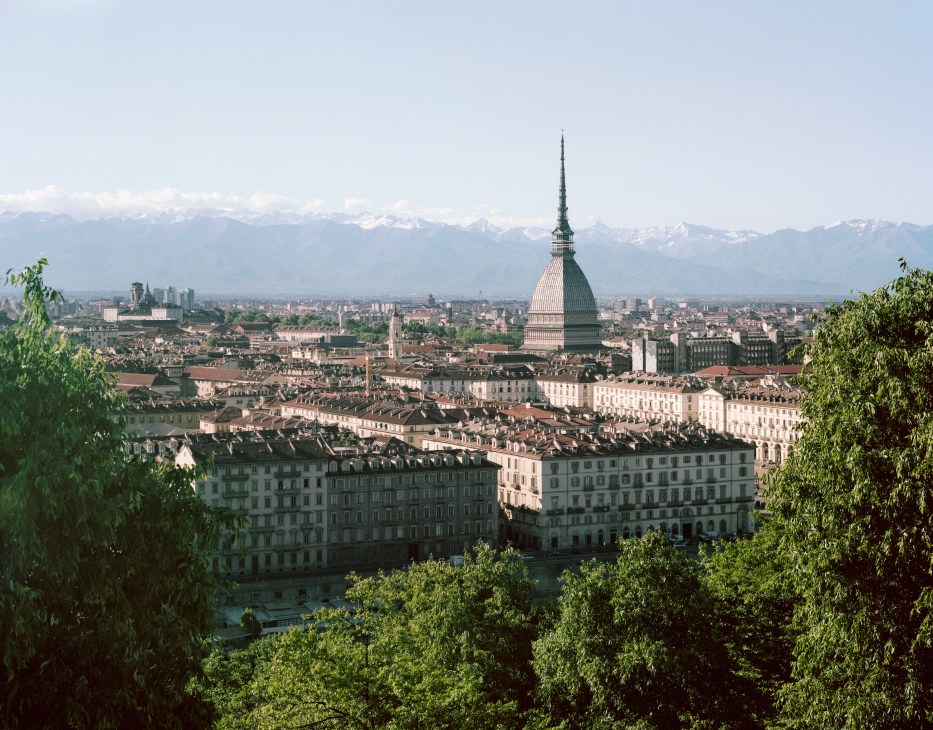 Turin cityscape with the Mole Antonelliana spire dominating the skyline, Alps in the background.