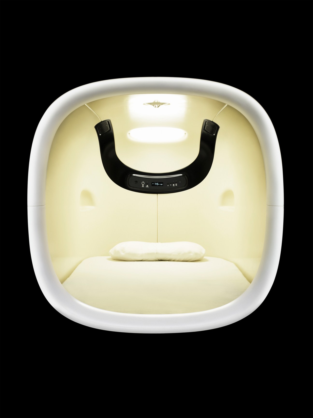 Interior view of a minimalist white capsule hotel pod with cream bedding and black technology control panel at 9 Hours, Kyoto.