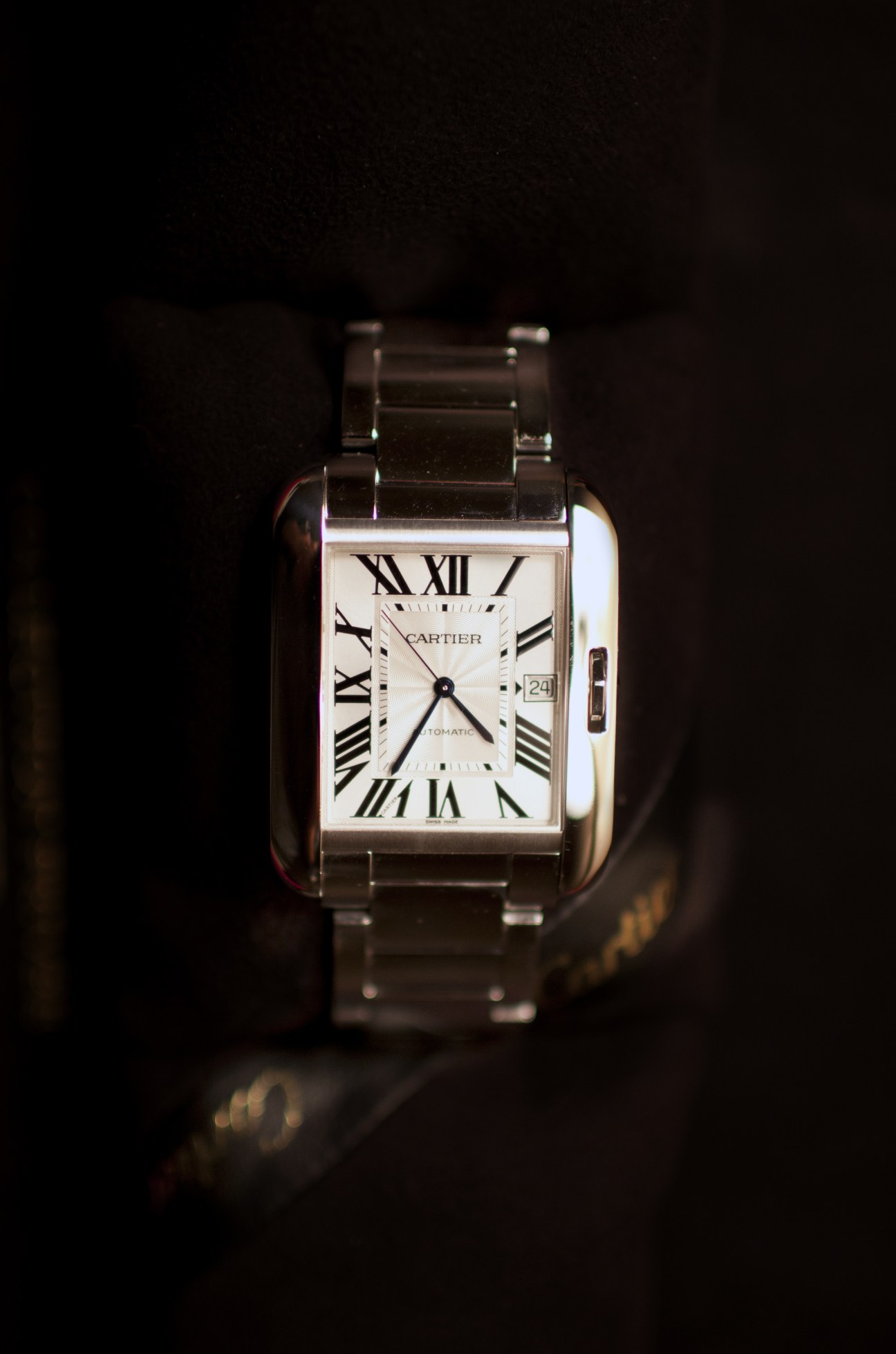 Cartier Tank Anglaise watch with rectangular white dial and Roman numerals on metal bracelet