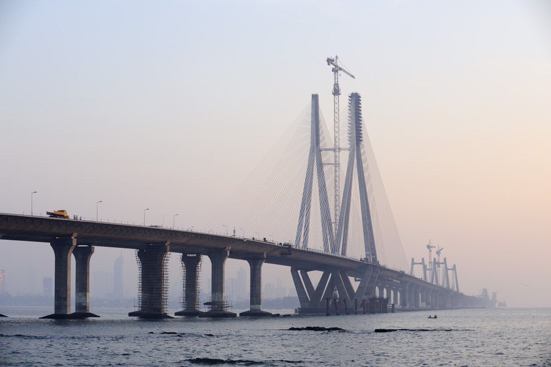 The Bandra-Worli Sealink bridge spanning across water with construction cranes visible during daytime.