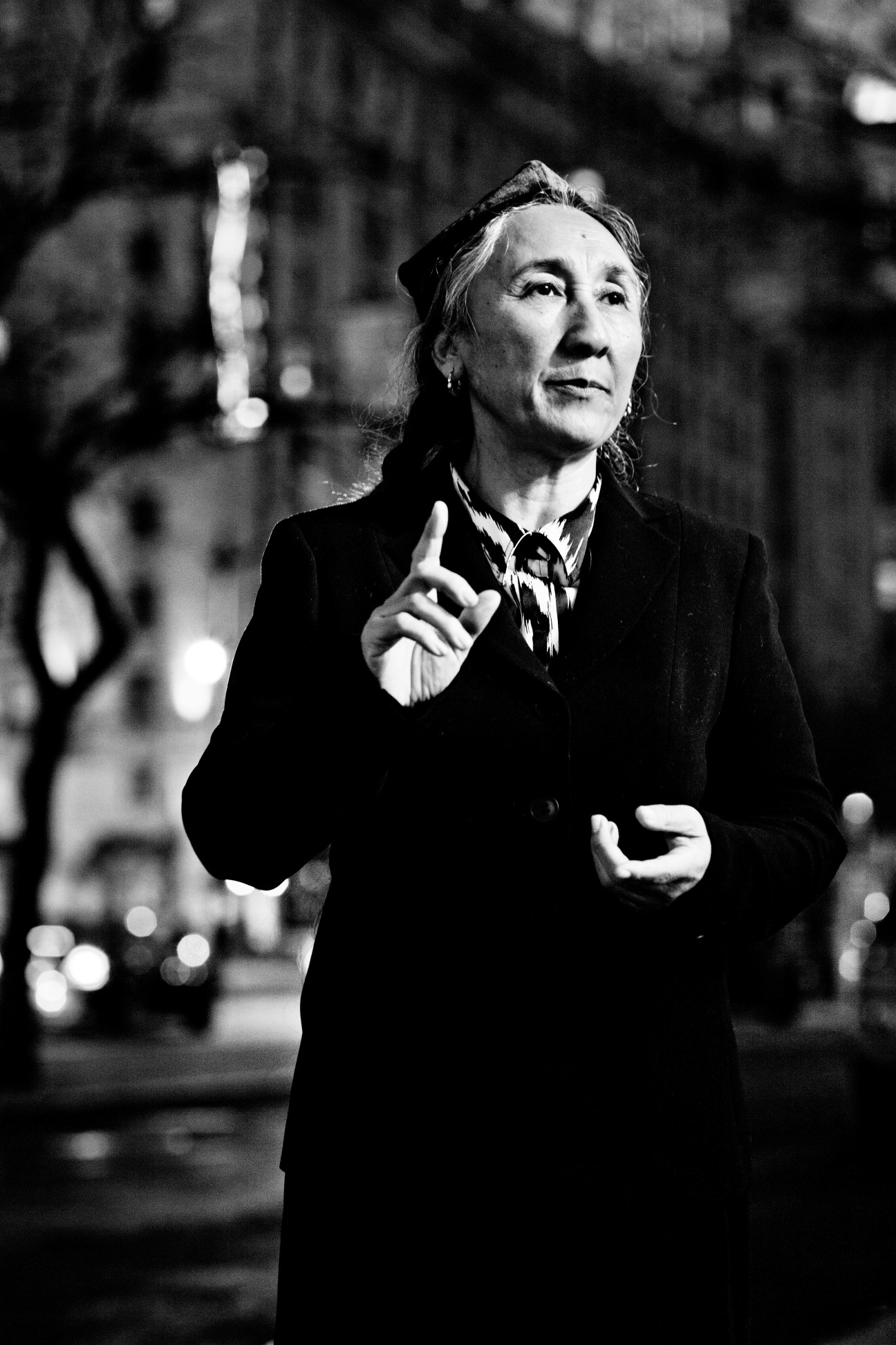 Rabiya Kadeer, Uyghur leader, gestures while speaking outdoors in black and white portrait.