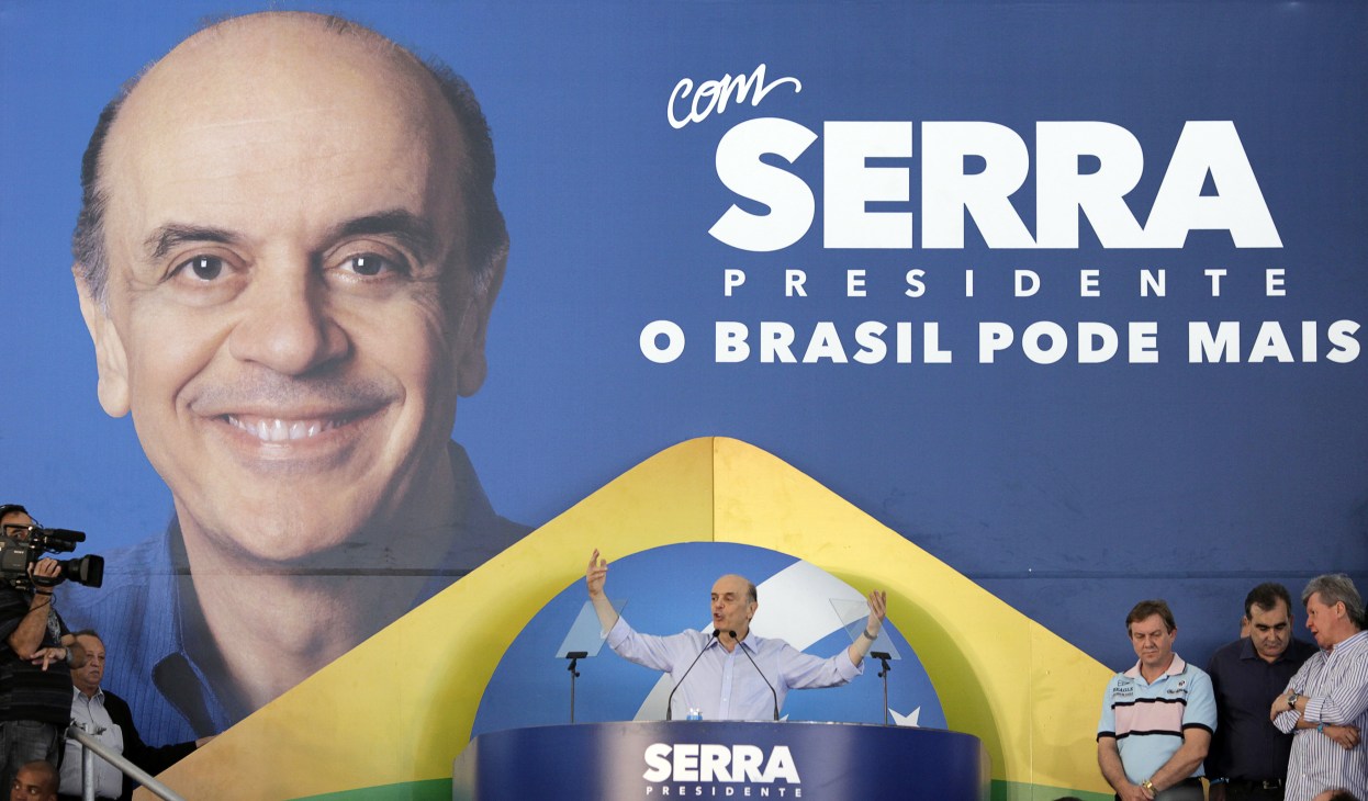José Serra at a campaign rally with his presidential campaign banner behind him.