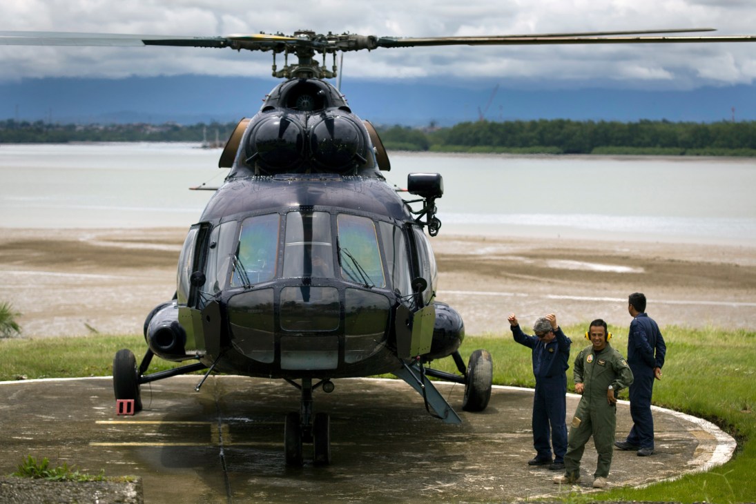 Russian-built Mi-17 helicopter lands at coastguard base in Buenaventura with personnel standing nearby.