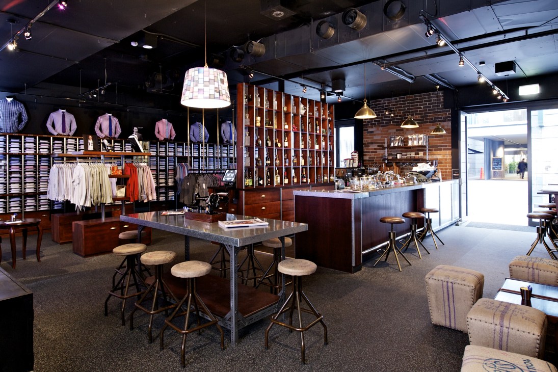 Interior of a modern retail space with clothing displays, a counter bar, and hanging pendant lights in Sydney's laneway.