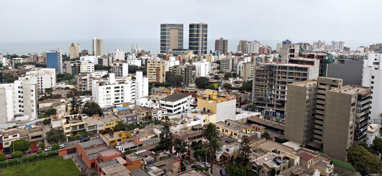 Aerial view of Miraflores district in Lima showing modern high-rise buildings and coastal landscape.