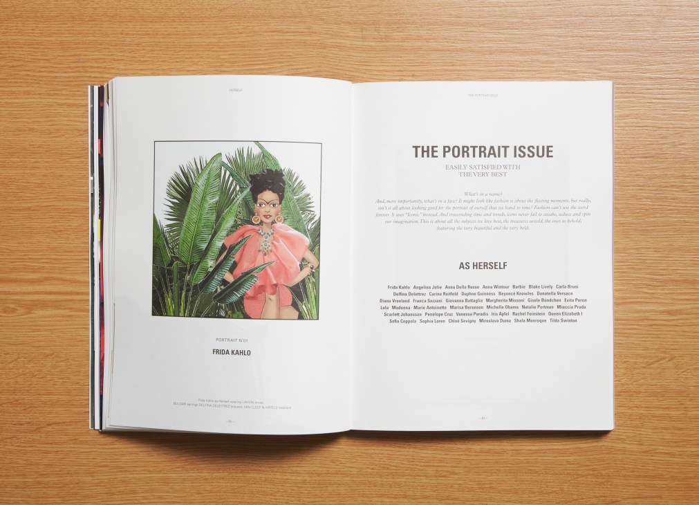 Open magazine spread showing Herself fashion publication's portrait issue featuring illustrated Frida Kahlo artwork on wood surface.