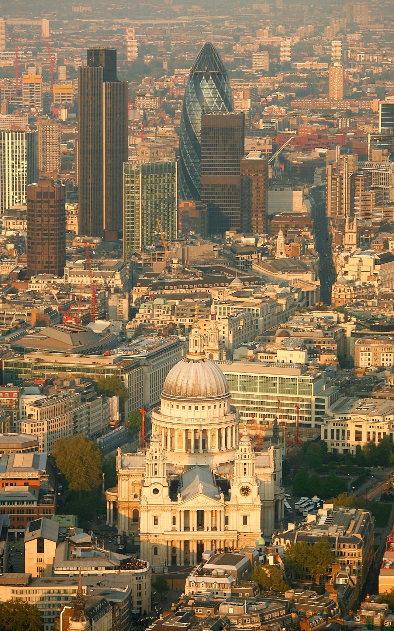 Aerial view of London's St Paul's Cathedral and surrounding cityscape at sunset.
