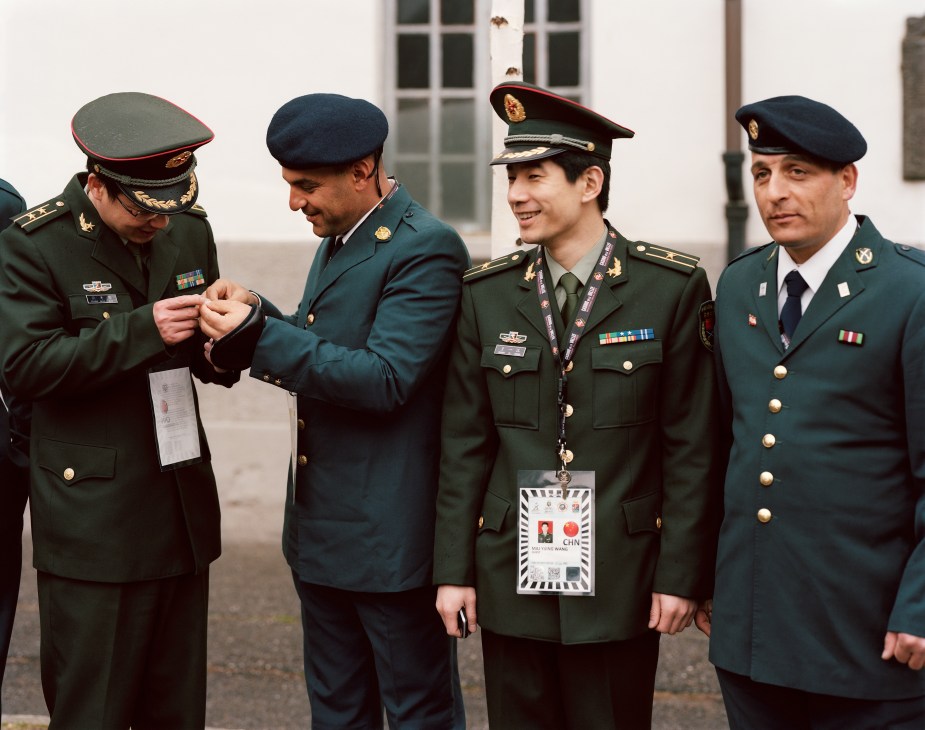Four military officers in dress uniforms conversing in a courtyard, including Chinese and Lebanese senior officers.