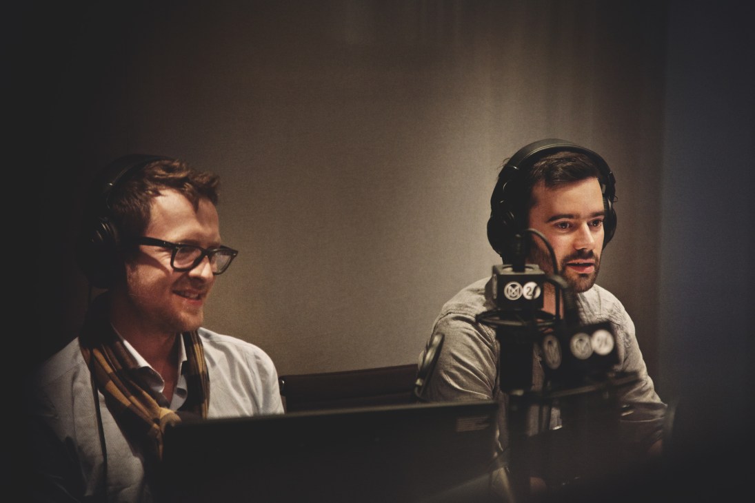 Hugo Macdonald and Steve Bloomfield wearing headphones in a Monocle 24 radio studio.