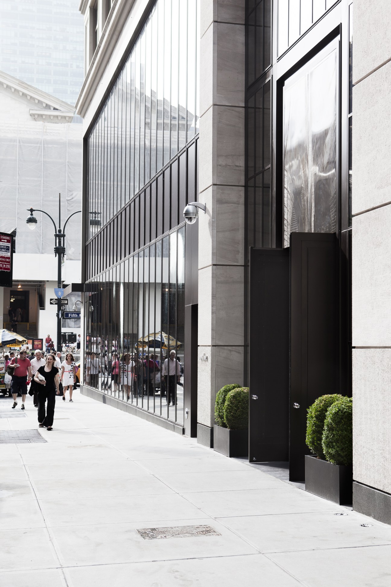 Andaz Fifth Avenue's 41st Street entrance with black metal frame doors and vertical slats on Fifth Avenue.
