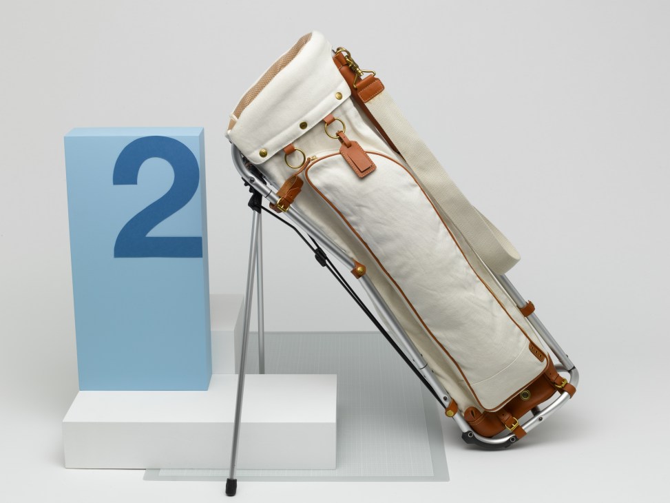 Kinoshohampu aluminium and canvas golf bag with leather trim displayed next to a blue number two marker.