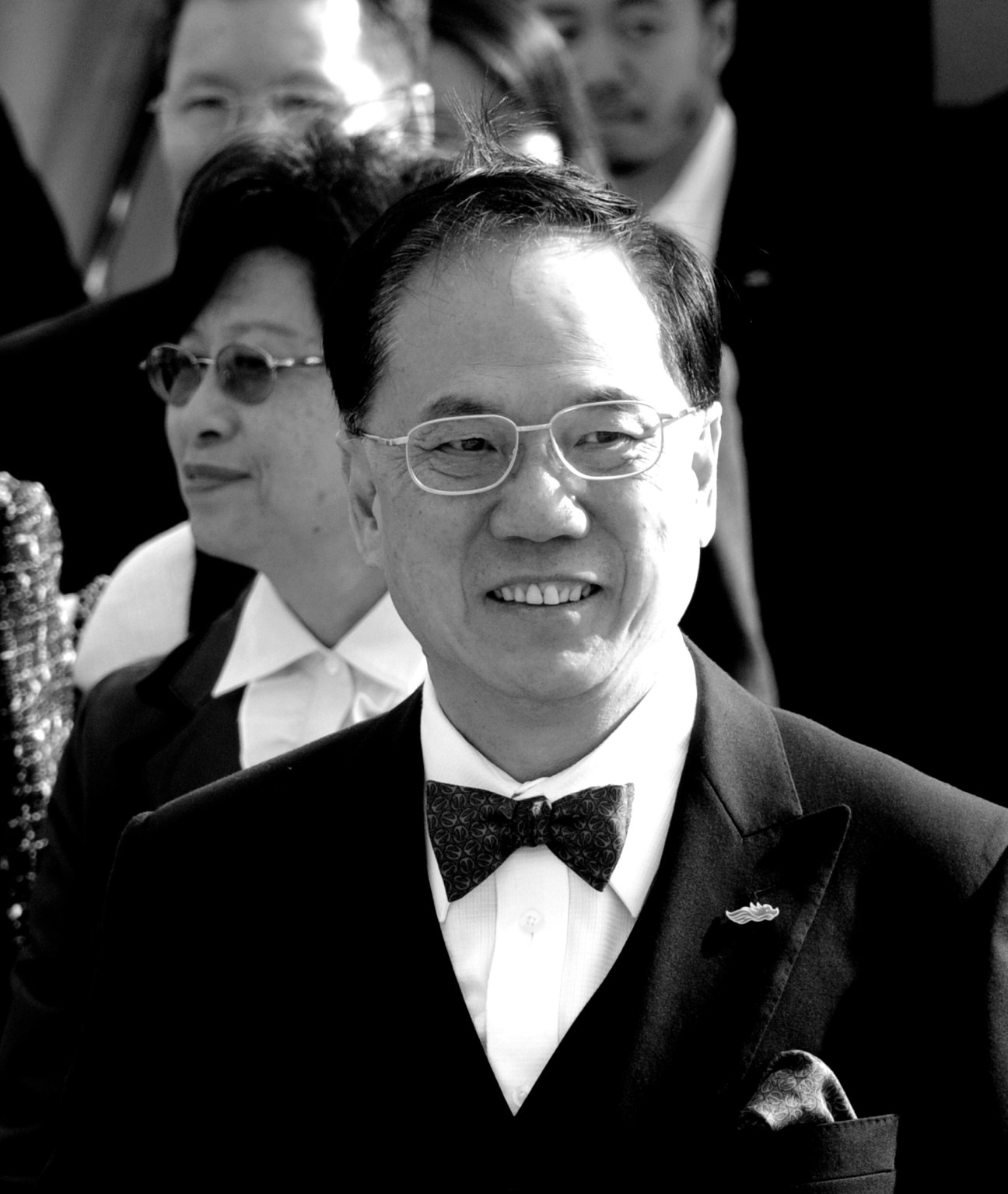 Black and white photograph of Hong Kong Chief Executive Donald Tsang wearing glasses and a bow tie with formal attire.