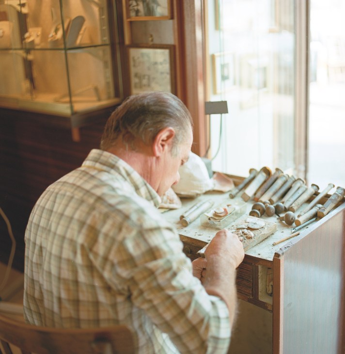 Craftsman hand-carving cameos at the De Paola factory workbench