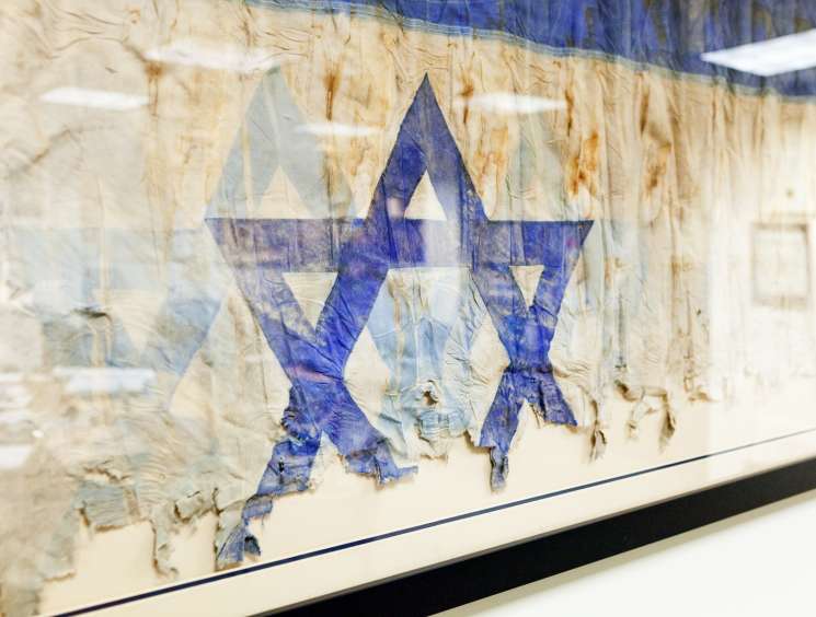 Israeli flag Star of David symbol displayed on weathered textured surface in diplomatic setting.