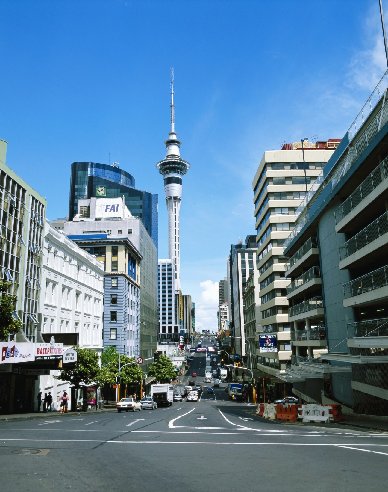 Auckland street with SkyTower and surrounding buildings under blue sky