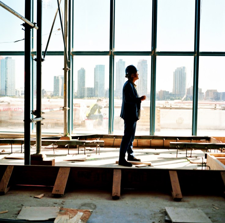 Mogens Morgen stands in the Trusteeship Council Chamber during restoration, with NYC skyline visible through floor-to-ceiling windows.