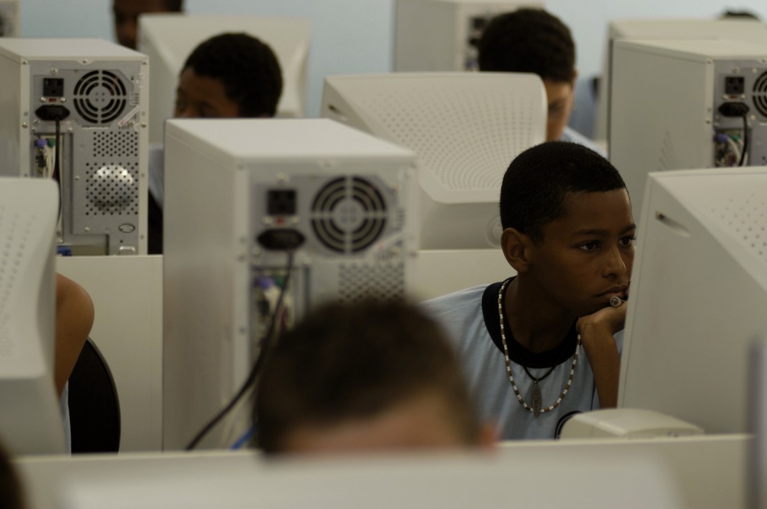 Young people sitting at computer terminals in an internet café.