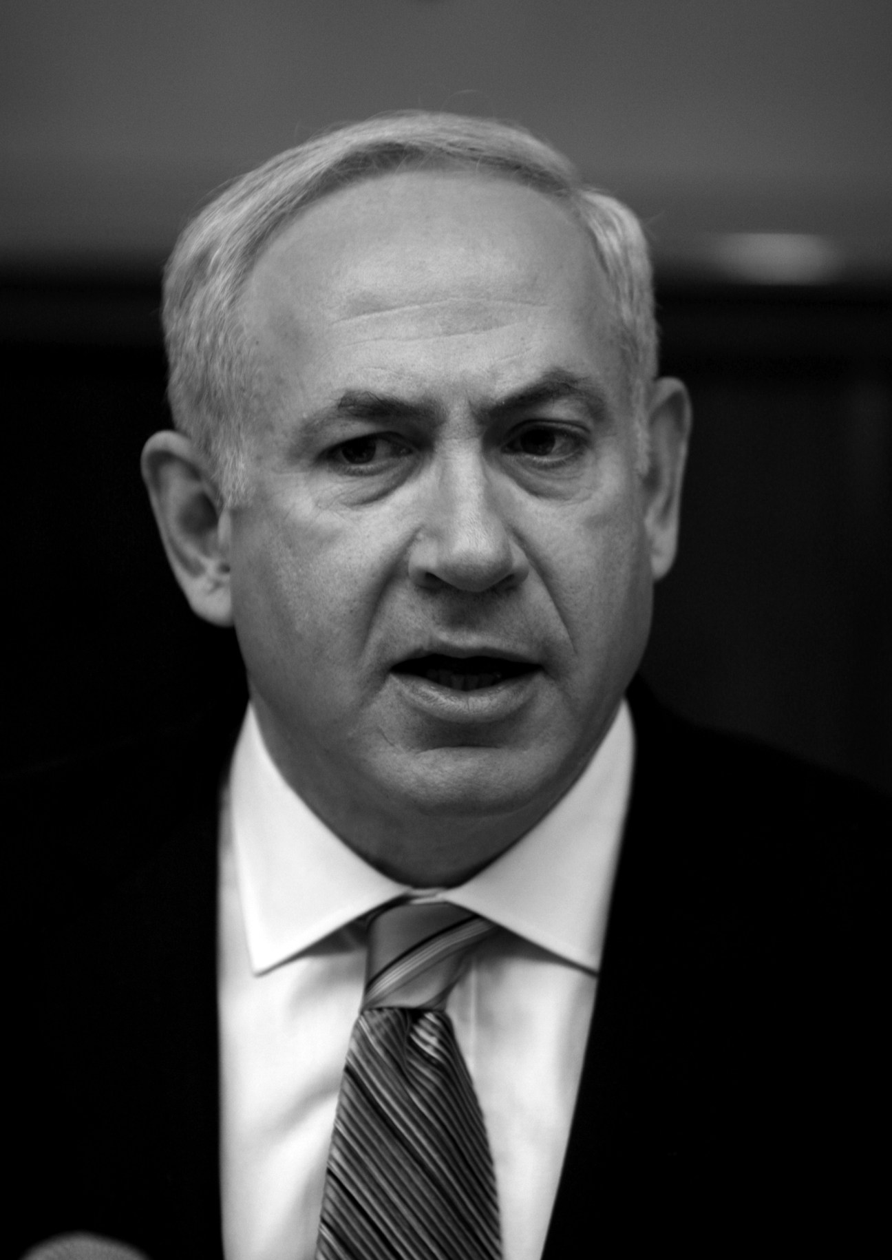 Black and white portrait of Benjamin Netanyahu, Israeli Prime Minister, wearing a white shirt and striped tie.