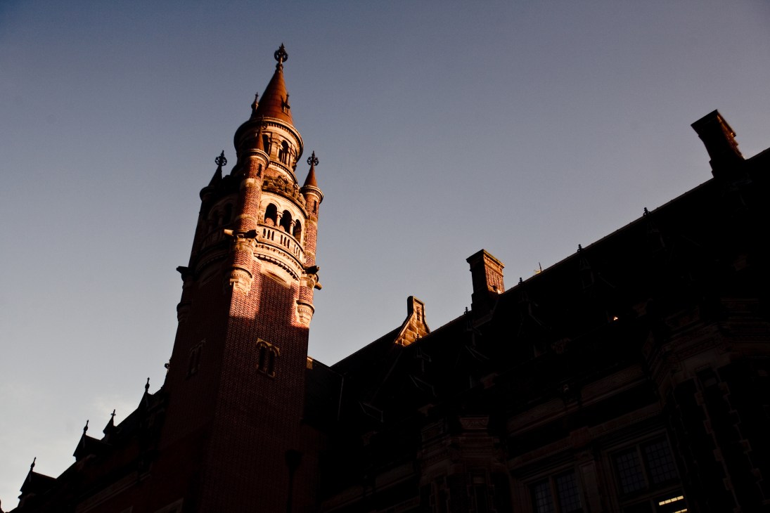 The Peace Palace's ornate brick spire with decorative finials against a clear sky.