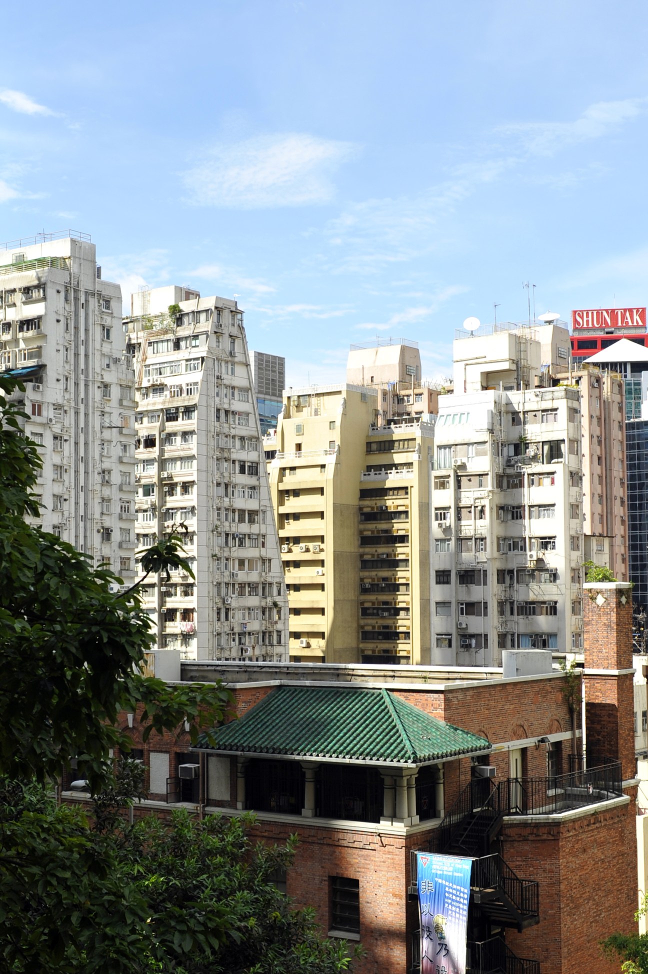 Mix of traditional residential apartment blocks and older brick building in Hong Kong's Sheung Wan district.