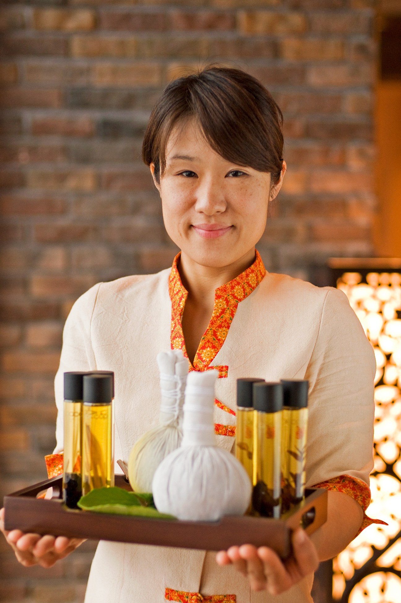 Ryoko Ado from Sankara Hotel's Asian Herb Association spa holds a tray of oils and herbs.