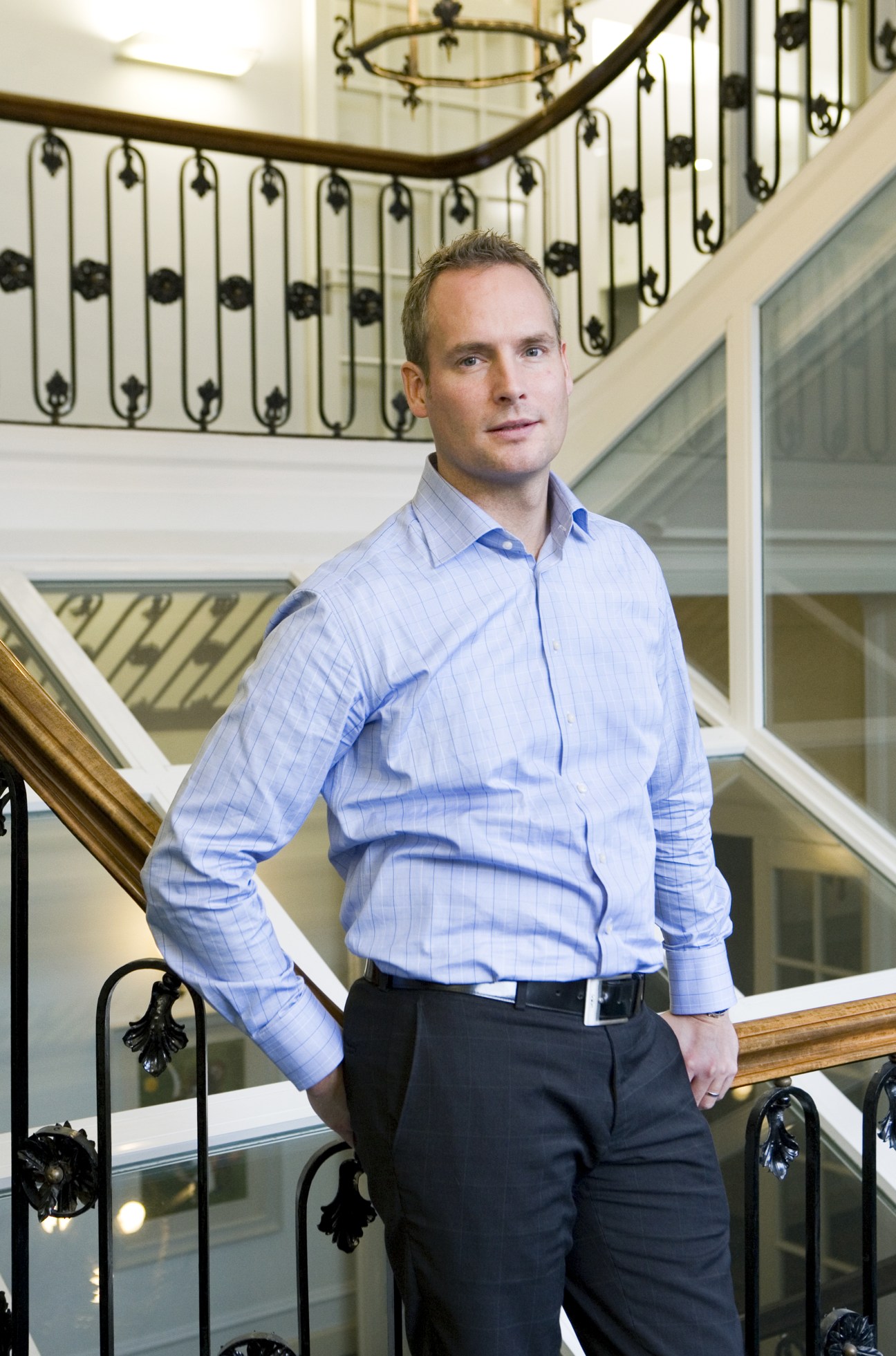 Jesper Bergendal, EF chief of staff, standing on a staircase in a blue shirt.