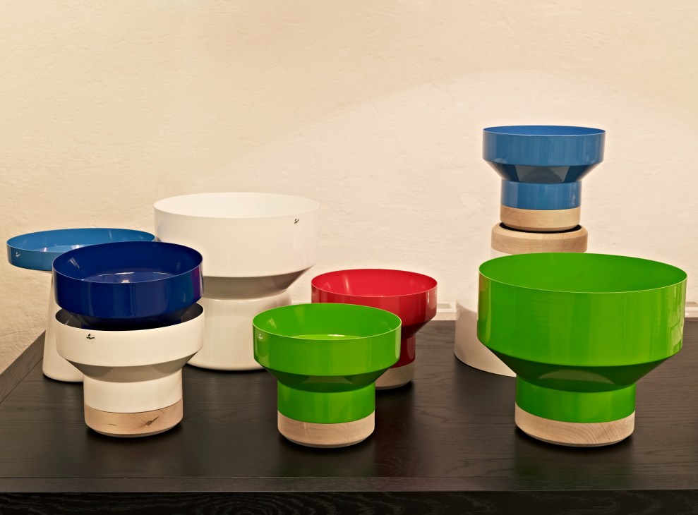 Colorful bowls and vases by Hello Industry designed by Jonas Wagell, featuring blue, white, green and red ceramic pieces with wooden bases.