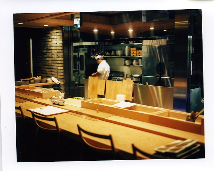 Yamato Raku restaurant counter with wooden seating and chef working in open kitchen