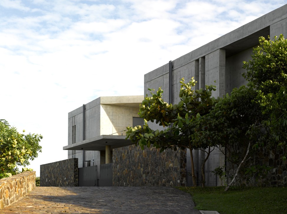 Tadao Ando-designed concrete house with angular walls surrounded by tropical vegetation and stone driveway.