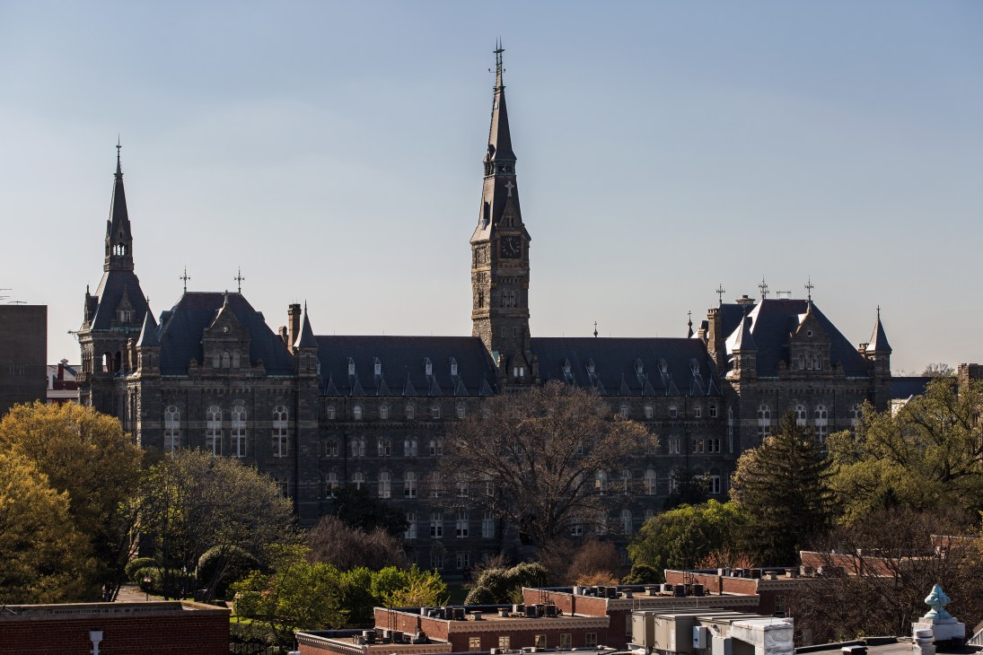 Georgetown University's Healy Hall with its distinctive Gothic Revival architecture and central spire surrounded by trees.