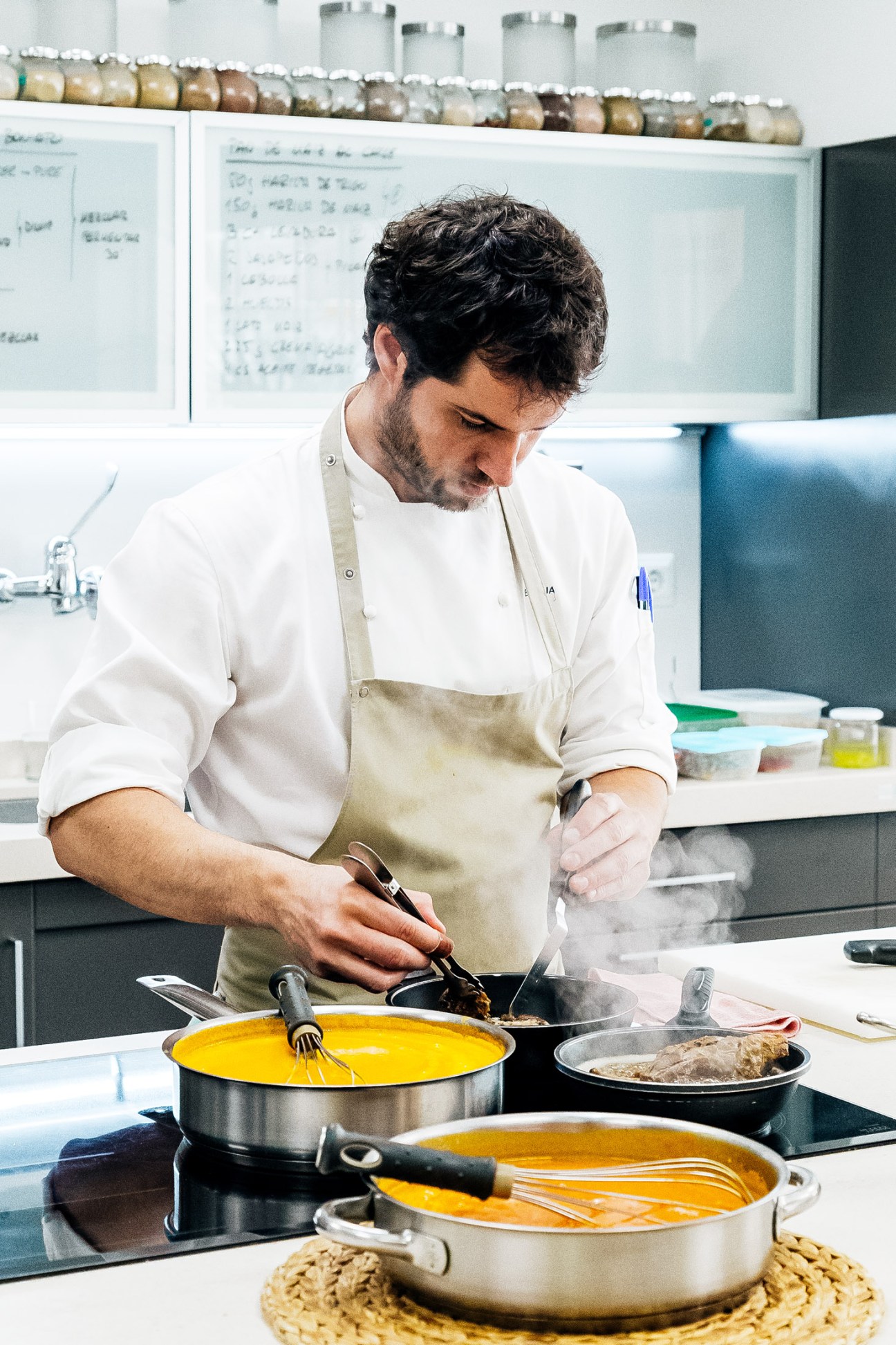 Chef Borja San Martín Casanellas cooking in an open kitchen at Taller Gastronómico Casanellas in Estella, Spain.