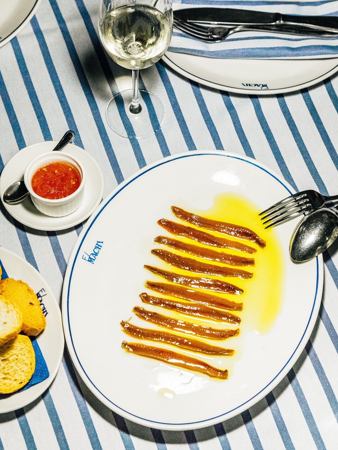 Plate of anchovy fillets in olive oil with white wine, tomato sauce and bread at El Machi restaurant.