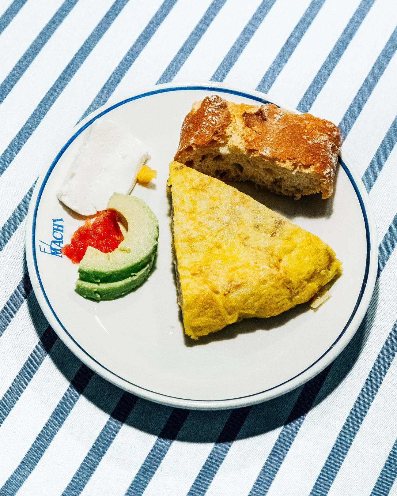 El Machi's Spanish tortilla served with avocado and red pepper on striped tablecloth