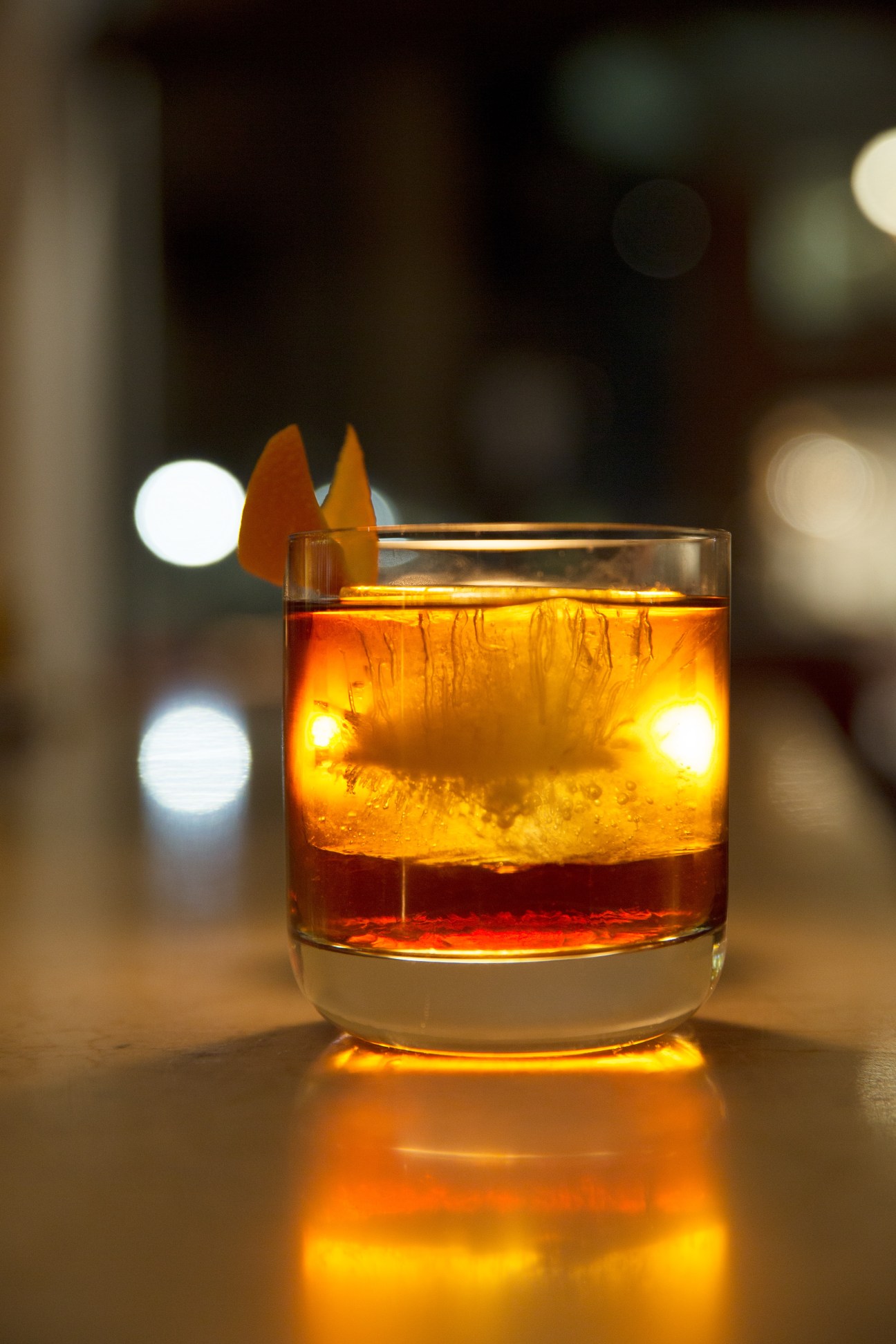 Harbour Street Manhattan cocktail with amber liquid, ice, and orange peel garnish.