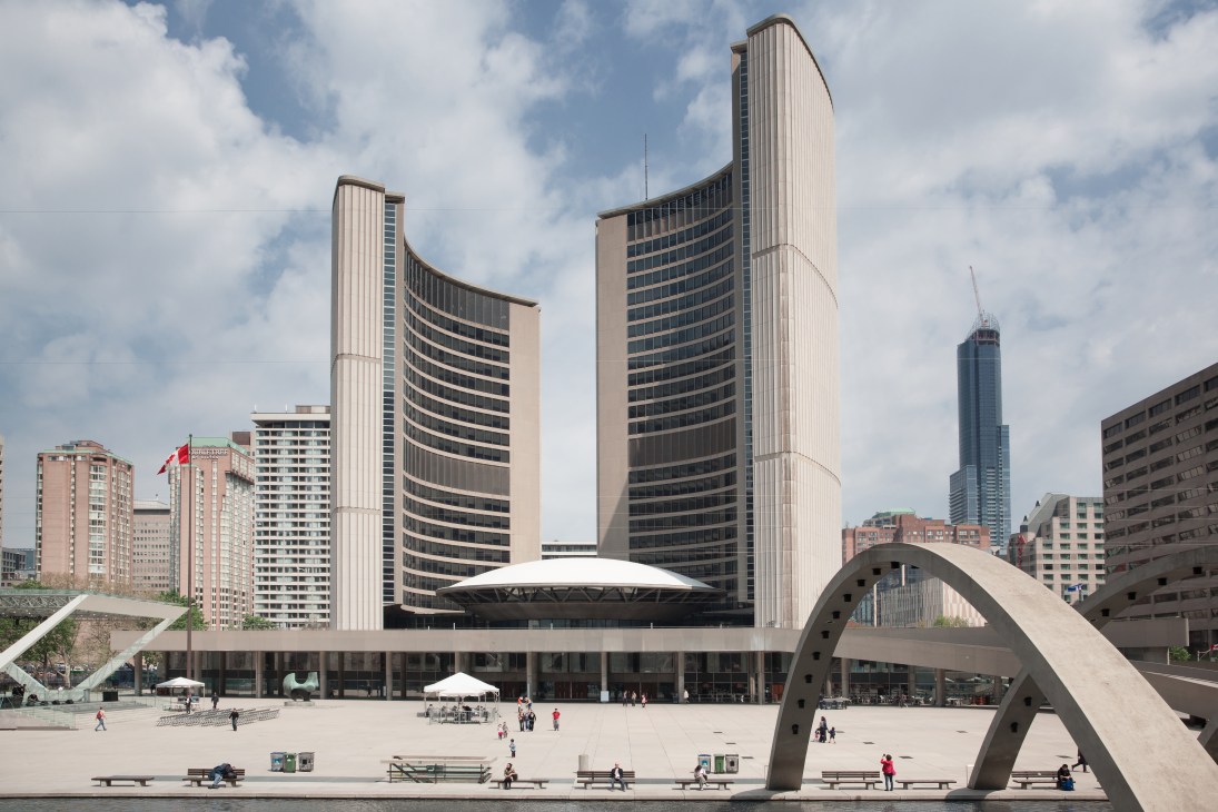 Toronto City Hall's modernist towers and flying saucer-shaped council chamber overlook Nathan Phillips Square with a Henry Moore sculpture in foreground.