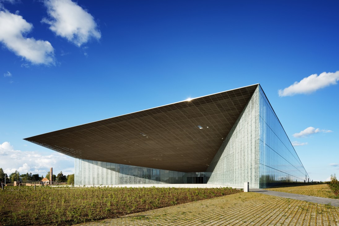 The Estonian National Museum building with angular glass and concrete exterior set in an open field.