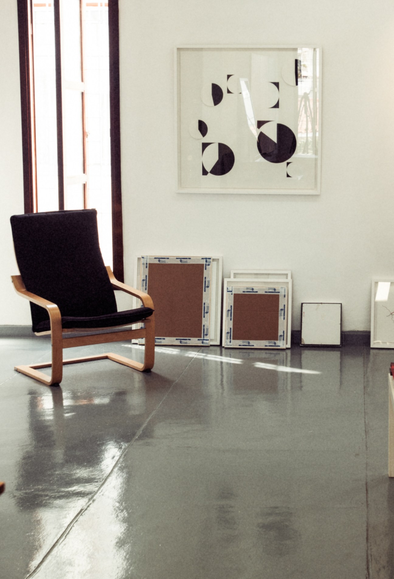 Abstract geometric artwork featuring black and white circular shapes mounted on a gallery wall