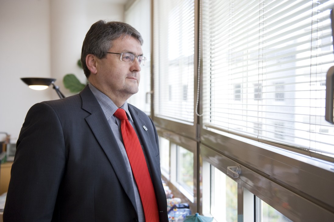 Heinz-Martin Dirks, Bochum's business development head, stands by an office window wearing a dark suit and red tie.